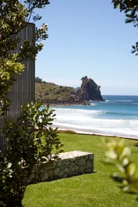 A scenic view of a beach with a rocky coast and clear blue skies.