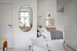 Minimalist living room with white furniture and soft furnishings.