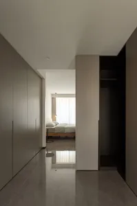 A modern minimalist bedroom with white walls and a minimalist bed.