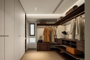 A modern closet with wooden shelves, hanging clothes, and a window.
