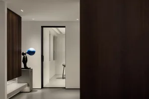 Modern entrance hall with metal and wood elements, featuring a blue and black sculpture.
