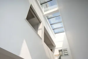Modern, minimalist space featuring large glass skylights providing natural light.