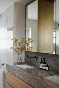 Modern bathroom with marble countertop, sink, and faucet.
