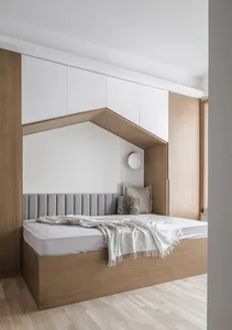 Modern minimalist bedroom featuring wooden furniture, white bedding, and a recessed sleeping area with a headboard and side t