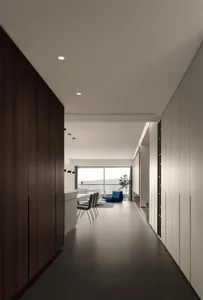 A minimalist living room with a black and white color scheme, concrete materials, and a view of the mountains.