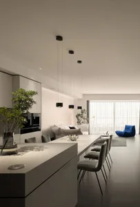 Modern minimalist living room and dining area with white concrete floor, minimalist furniture, and white cabinets.