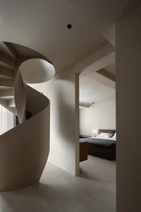 Modern residential interior featuring a spiral staircase made of concrete and wooden walls.