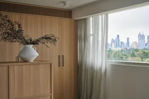 A modern residential interior featuring wooden cabinets and glass curtains.
