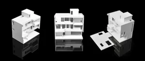 White architectural model of a modular building structure on a black reflective surface.