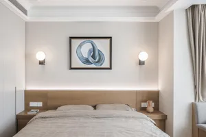 A minimalist bedroom with a wooden headboard and fabric bedding, featuring a framed abstract painting with blue shapes and a