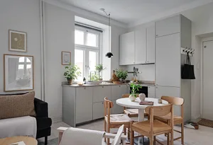 Modern minimalistic living and dining space featuring wooden furniture, metal accents, and concrete surfaces