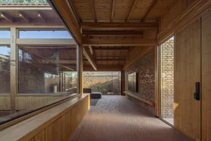 A modern interior space featuring wood elements and large windows.