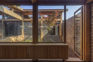 Modern living space with wooden walls, brick floors, and glass windows.