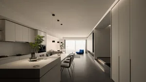 A modern minimalist kitchen with concrete and white countertops, pendant lights, and a green plant in a vase on the counterto