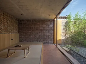 A modern living space featuring brick walls and concrete flooring.