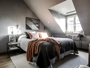 A minimalist bedroom with a bed, window, and some decorative items on the windowsill.