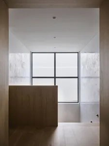 An empty minimalist interior space with concrete and wooden walls and floor.