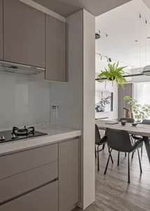Kitchen with minimalist design, neutral tones, and glass backsplash.