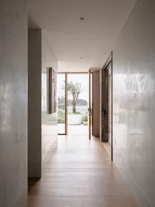 A modern marble hallway with a view leading to an outdoor patio area.