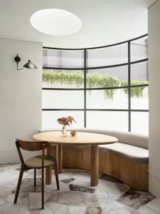 A minimalist interior with a wooden table and marble floor.