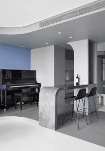 Modern living room featuring black piano and concrete kitchen island
