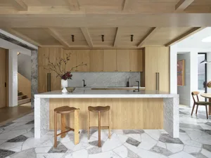 A modern kitchen featuring wooden cabinets and marble countertops.