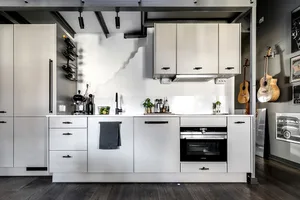 Modern kitchen featuring metal cabinets, wooden countertops, and glass backsplash.