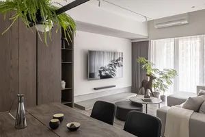Minimalist modern living room with white walls, wooden floor, and grey furniture.