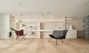 A modern living room featuring wood flooring and white walls and furniture.
