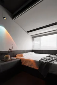 Modern minimalist bedroom with minimalist bed, white bedding, and wooden headboard.
