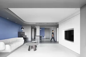 A modern, minimalist living room featuring a white sectional sofa, concrete flooring, and a piano in the corner.