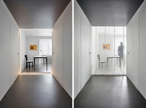 Minimalist white-walled room with white panels and desk area.