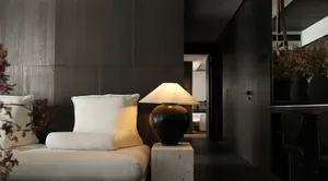 Minimalist living room with concrete furniture and white cushions on a white sofa.