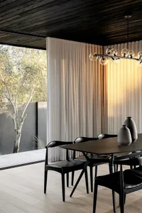 Modern dining room featuring contemporary furnishings, glass curtains, and minimalist decor.