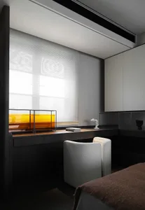 A minimalist bedroom with wooden furniture, glass panels, and metal accents.