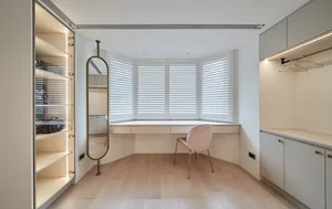 A minimalist wardrobe room featuring wood, glass, and metal materials, with a large mirror and a comfortable seating area und