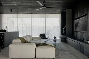 Contemporary living room featuring modern concrete finishes and sophisticated lighting fixtures.