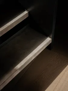 Modern staircase with leather treads against a dark background