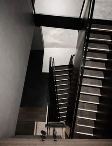 An industrial-style staircase constructed from concrete, viewed from an elevated angle.