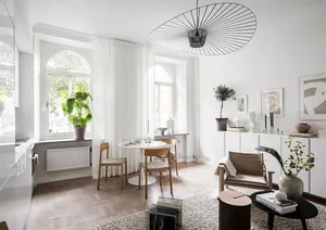 Modern minimalist living room featuring a white cement floor and wooden furniture.