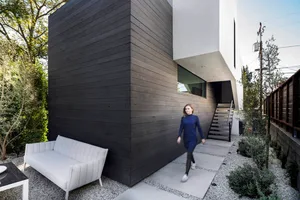 A modern residential exterior featuring concrete and wood materials.