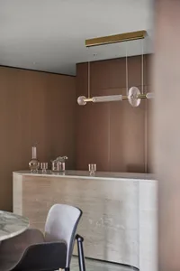 Modern bar counter featuring glass, brass, and marble materials.
