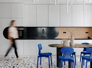 A modern kitchen with a black granite countertop and a terrazzo floor.
