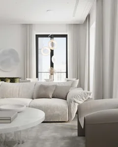 A modern living room with a large sectional sofa, upholstered in a soft, beige fabric, and complemented by neutral-colored cu