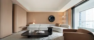 Modern residential living room featuring a stylish white leather couch with wood panel walls and a coffee table.