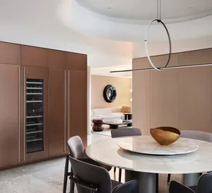 Modern residential interior design featuring marble kitchen countertops, copper cabinets, and wooden flooring and furniture.