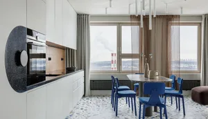 Modern residential interior with white cabinets, blue furniture, and marble countertops.