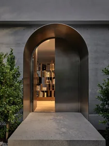 An arched metallic entranceway leading into a space filled with books.