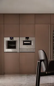 A modern, industrial-style kitchen with metallic cabinetry and appliances.