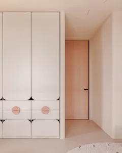 Minimalist white wardrobe with pink circular knobs.